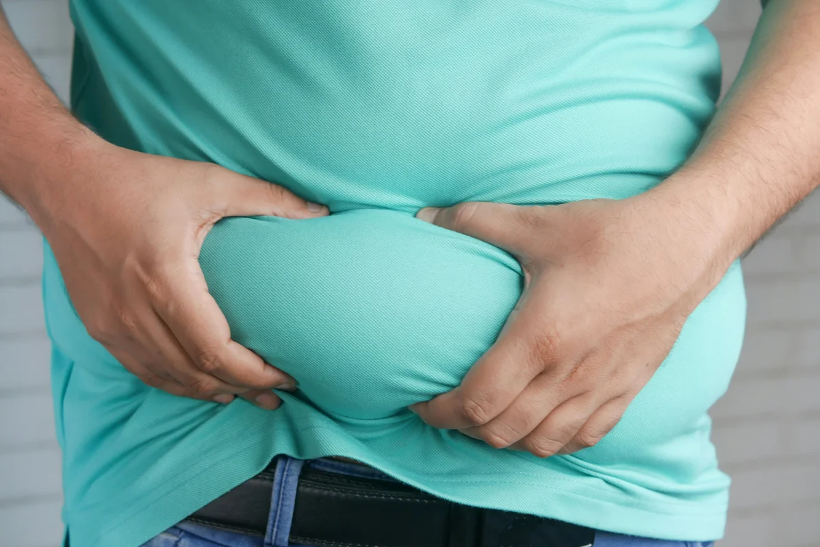 person holding stomach in discomfort