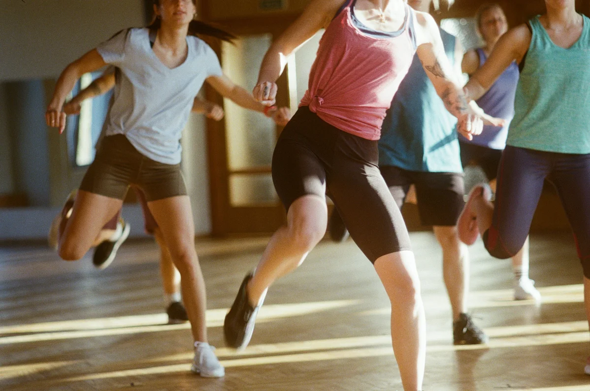 A group of participants engaged in a fitness class at the gym A group of participants engaged in a fitness class at the gym