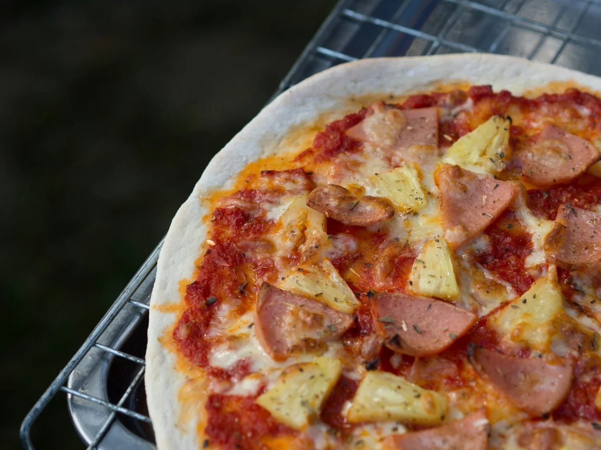 A perfectly grilled Hawaiian pizza, showcasing the vibrant toppings and crust A perfectly grilled Hawaiian pizza, showcasing the vibrant toppings and crust