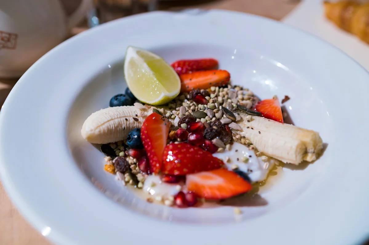 Bowl of Greek yogurt topped with fresh fruits and nuts
