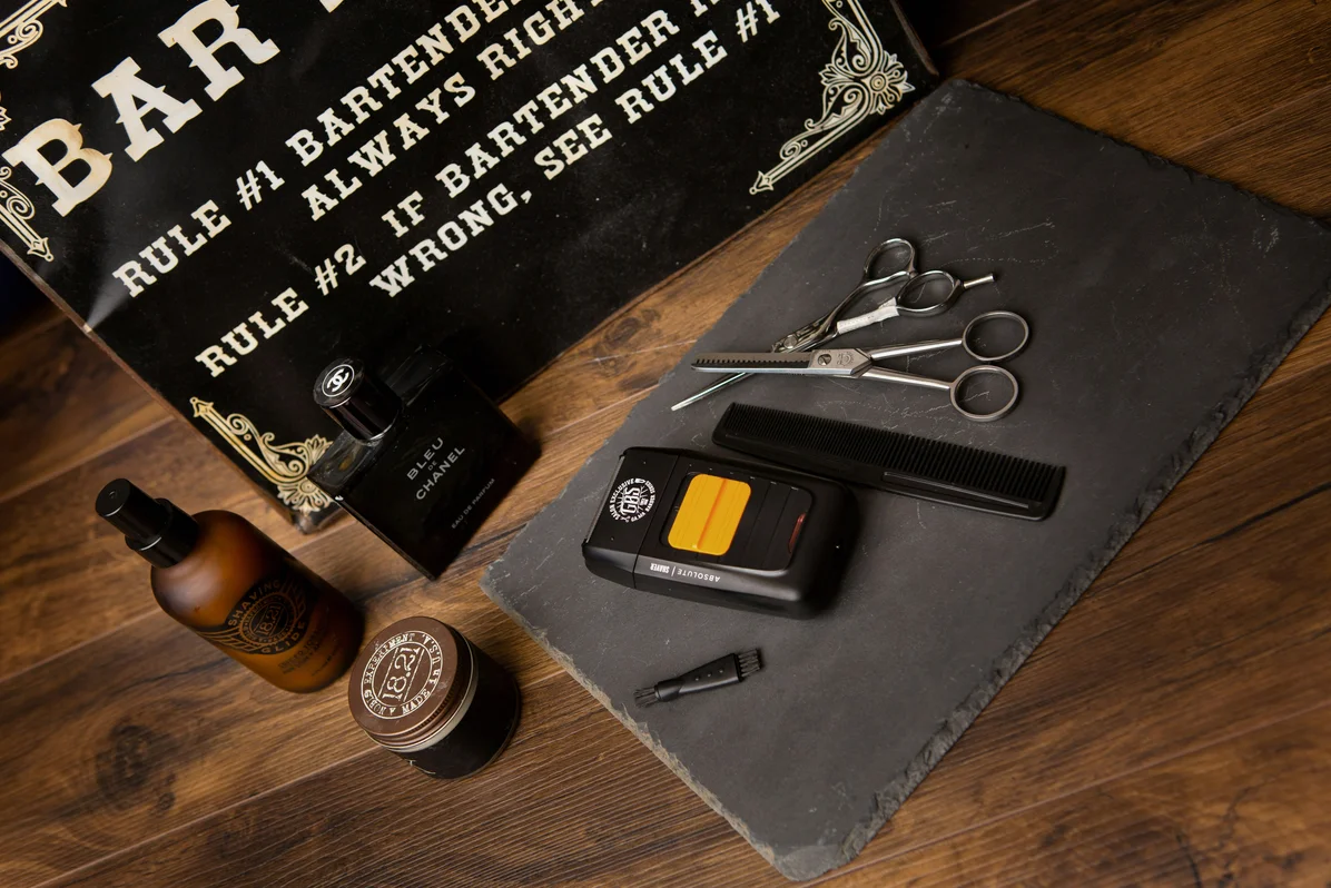 Various beard grooming tools including combs and oils displayed on a wooden table