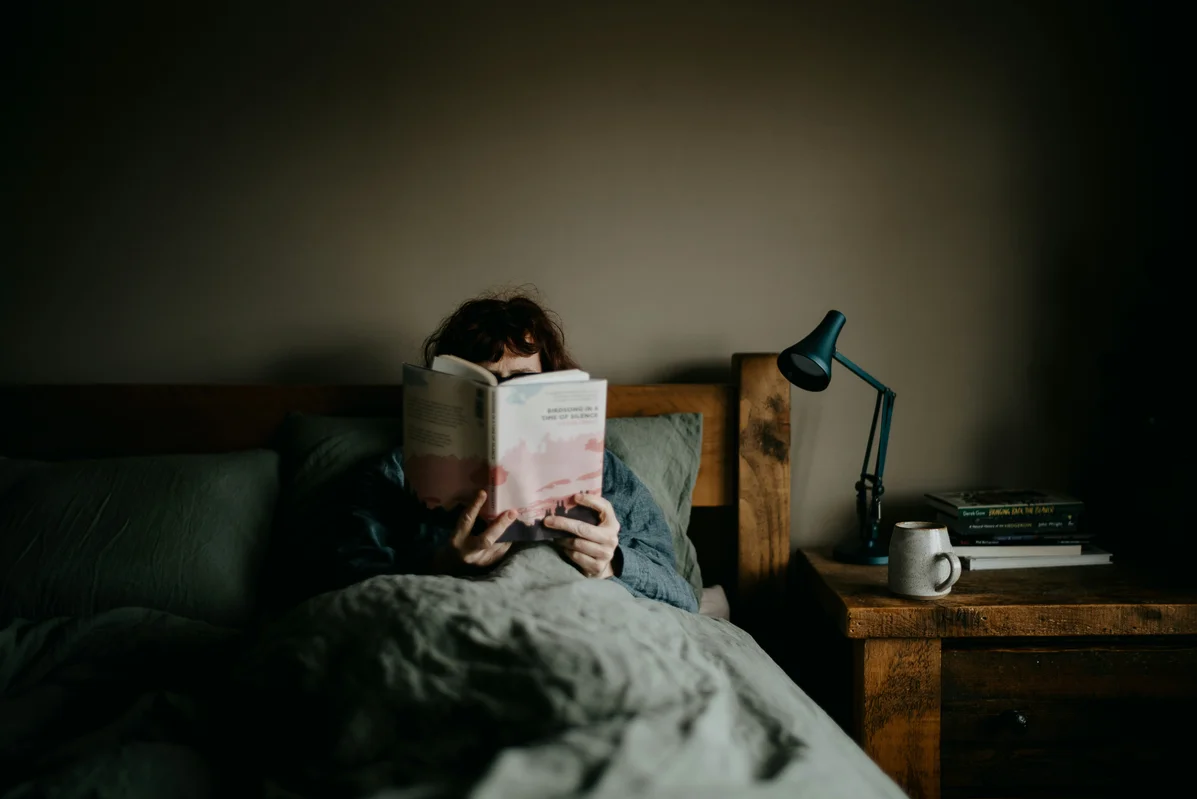 A person enjoying a calming bedtime routine, contributing to better sleep consistency A person enjoying a calming bedtime routine, contributing to better sleep consistency
