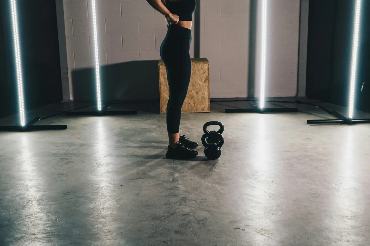 Person performing kettlebell swings in a gym setting