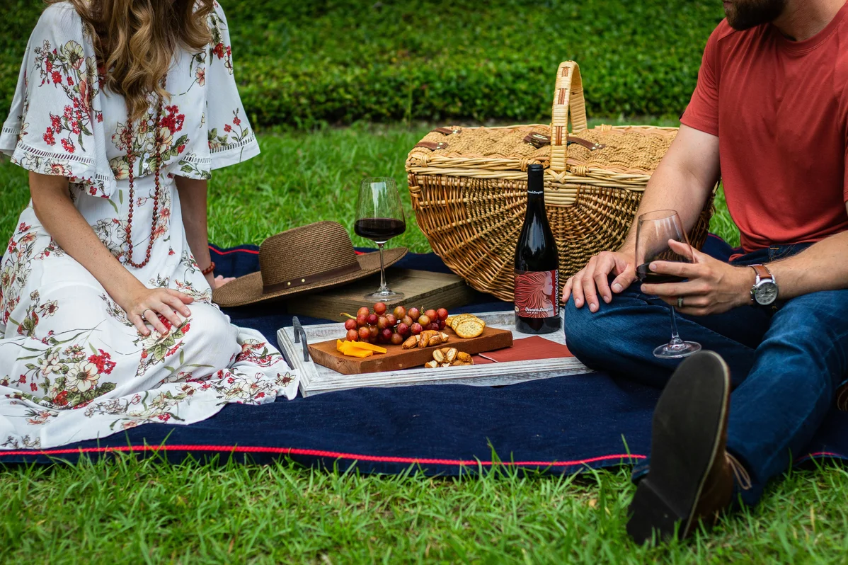A couple enjoying a picnic together in the park A couple enjoying a picnic together in the park