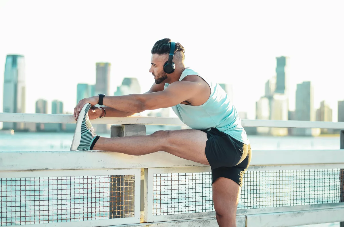 A runner stretching on a track to relieve side stitches A runner stretching on a track to relieve side stitches