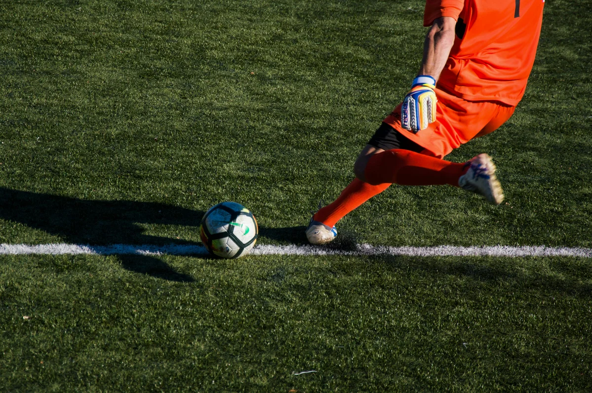 Soccer player performing curtsy lunges on the field during training Soccer player performing curtsy lunges on the field during training