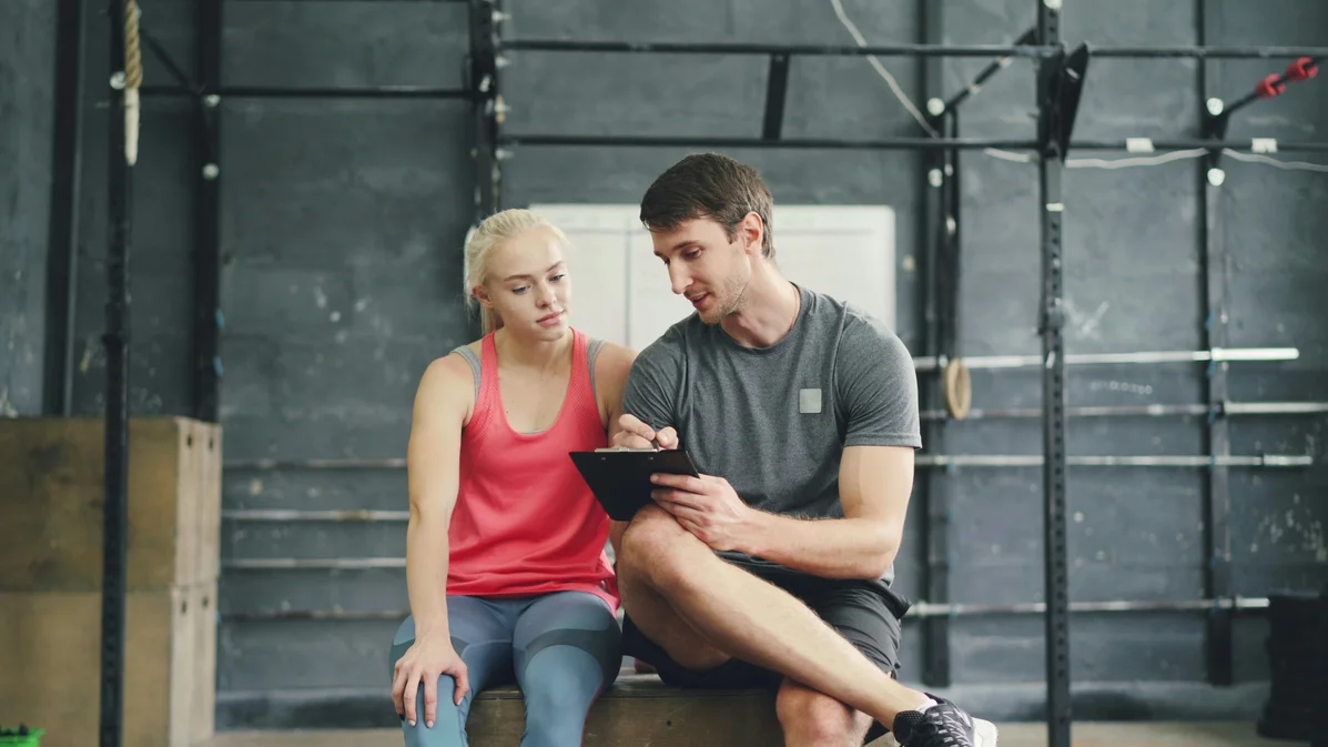 Personal trainer guiding a client in strength training exercises