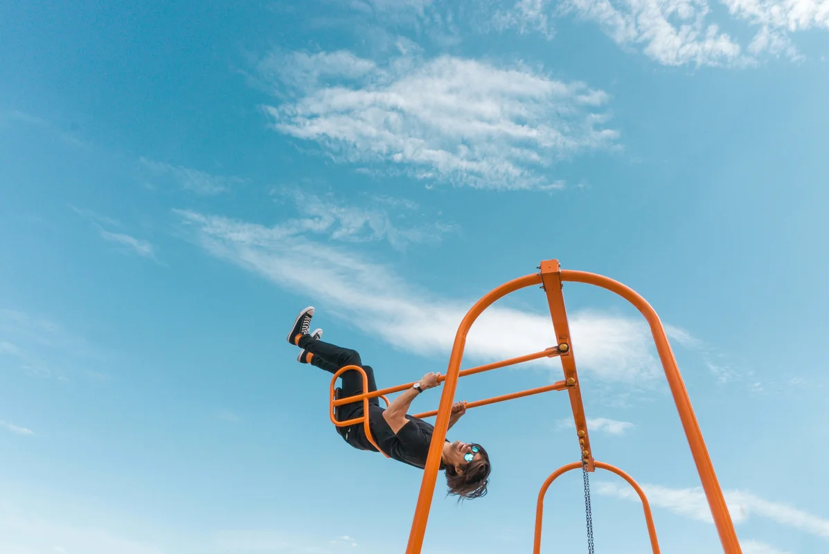 A person hanging from a pull-up bar, demonstrating grip strength training